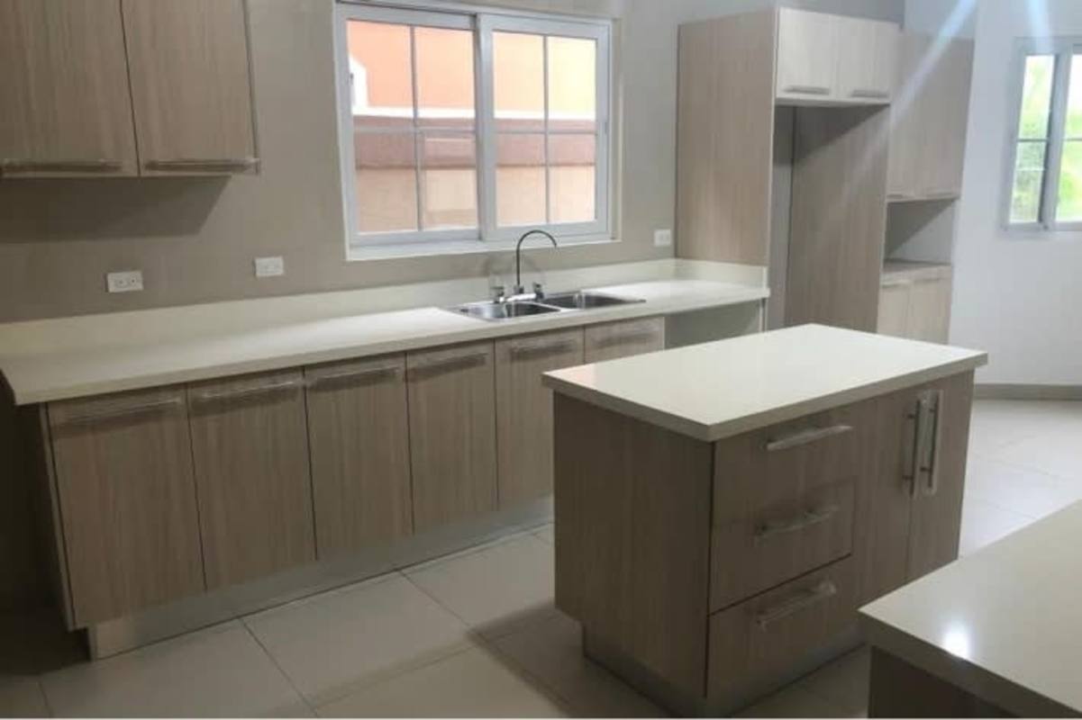 Spacious modern kitchen with island, double sink, and ample cabinets in Costa Sur luxury villa