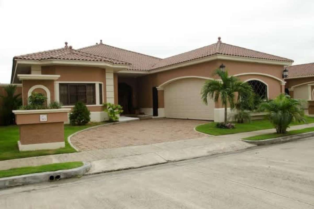 Secure Mediterranean-inspired entrance to Sunset Coast gated community with landscaped gardens in Panama City