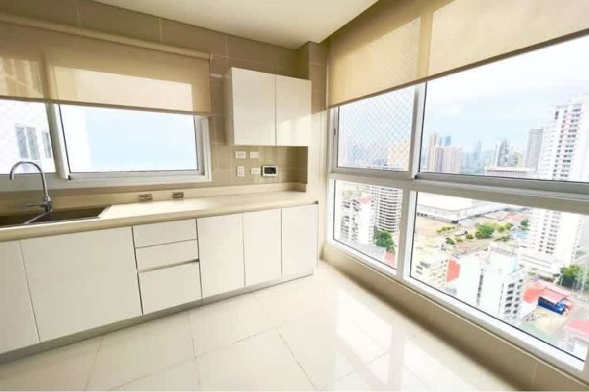Modern bright kitchen with large windows and city skyline view at PH Windrose Panama City