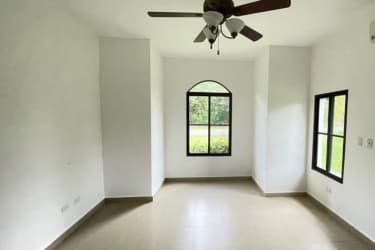 Bedroom with ceiling fan, large window, garden views Hacienda Pacífica villa Panama