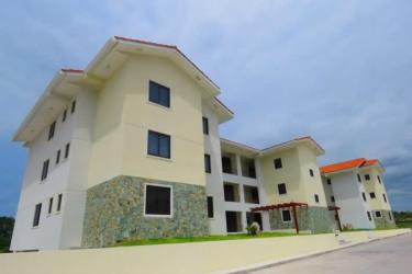 Modern apartment building exterior with balconies and covered parking in Marina Golf San Carlos Panama