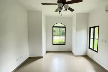 Bright bedroom with large windows, tiled floor, ceiling fan in Hacienda Pacífica Panama