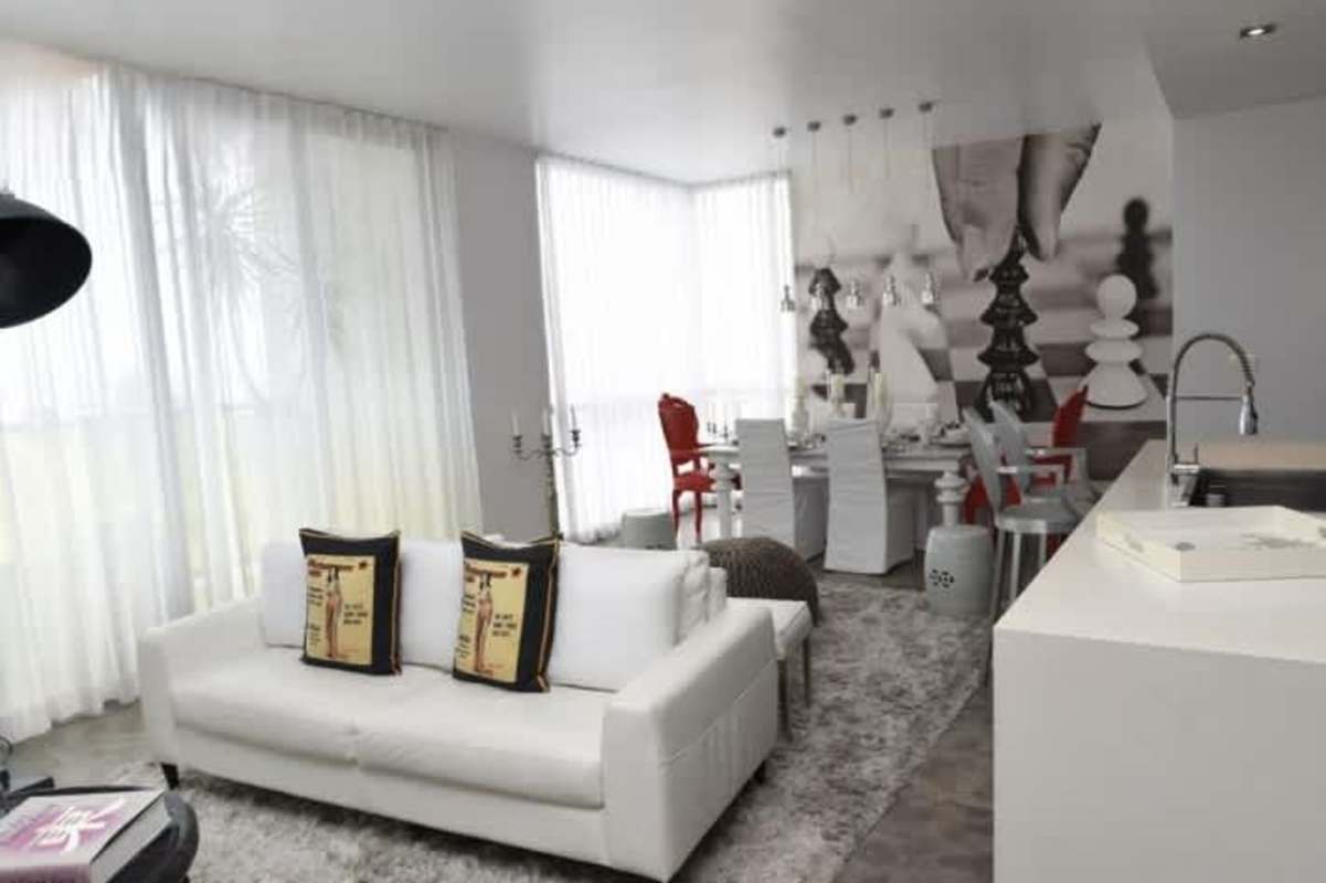 Dining room with large chess mural, open-concept modern design and panoramic windows in Yoo Panama apartment