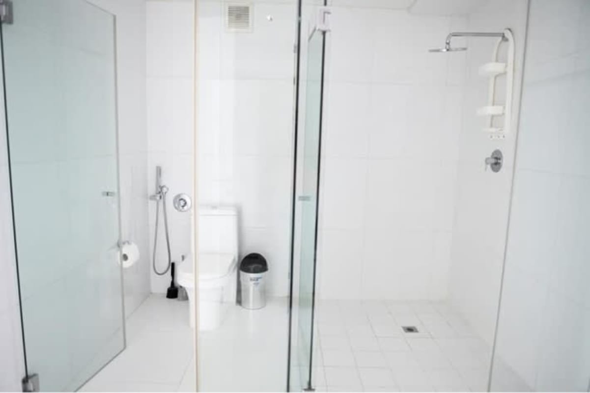 Modern white bathroom with glass shower in Yoo Panama Arts Tower