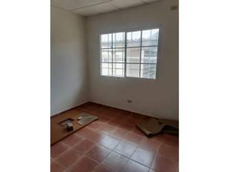 Minimalist bedroom with large window and ceramic tile floor in Chitré Panama house