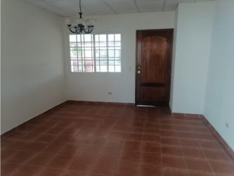Empty living room with tiled floor, wooden door and window in Chitré Panama