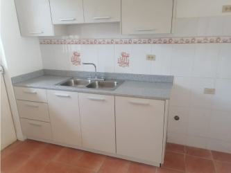 Simple kitchen with white cabinets, grey countertop and double sink in Chitré Panama