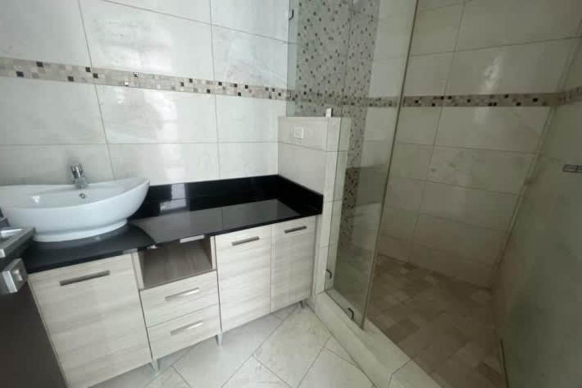 Modern bathroom with glass enclosed shower, tile finishes, marble countertop PH Grand Tower Punta Pacifica