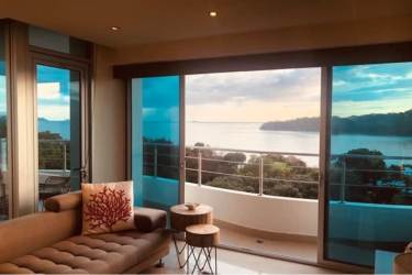 Curved balcony overlooking the Pacific Ocean sunset with outdoor furniture at Casa Bonita Playa Bonita