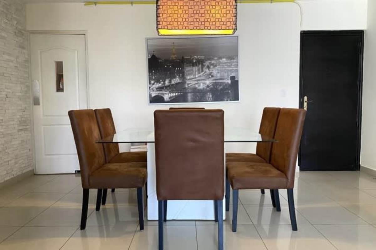 Stylish dining area with glass table and stone accent wall PH San Francisco Bay Panama
