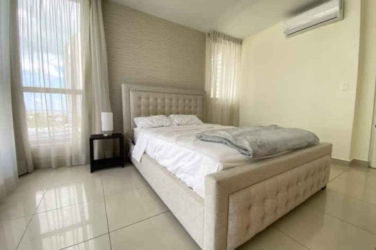 Bedroom with large windows, upholstered bed, AC and closet in San Francisco Bay Panama