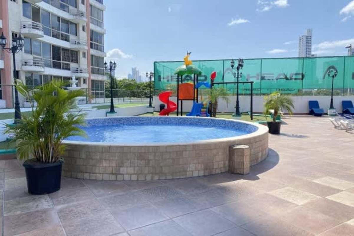 Outdoor pool, jacuzzi, tennis court, gym area with skyline backdrop at San Francisco Bay Panama