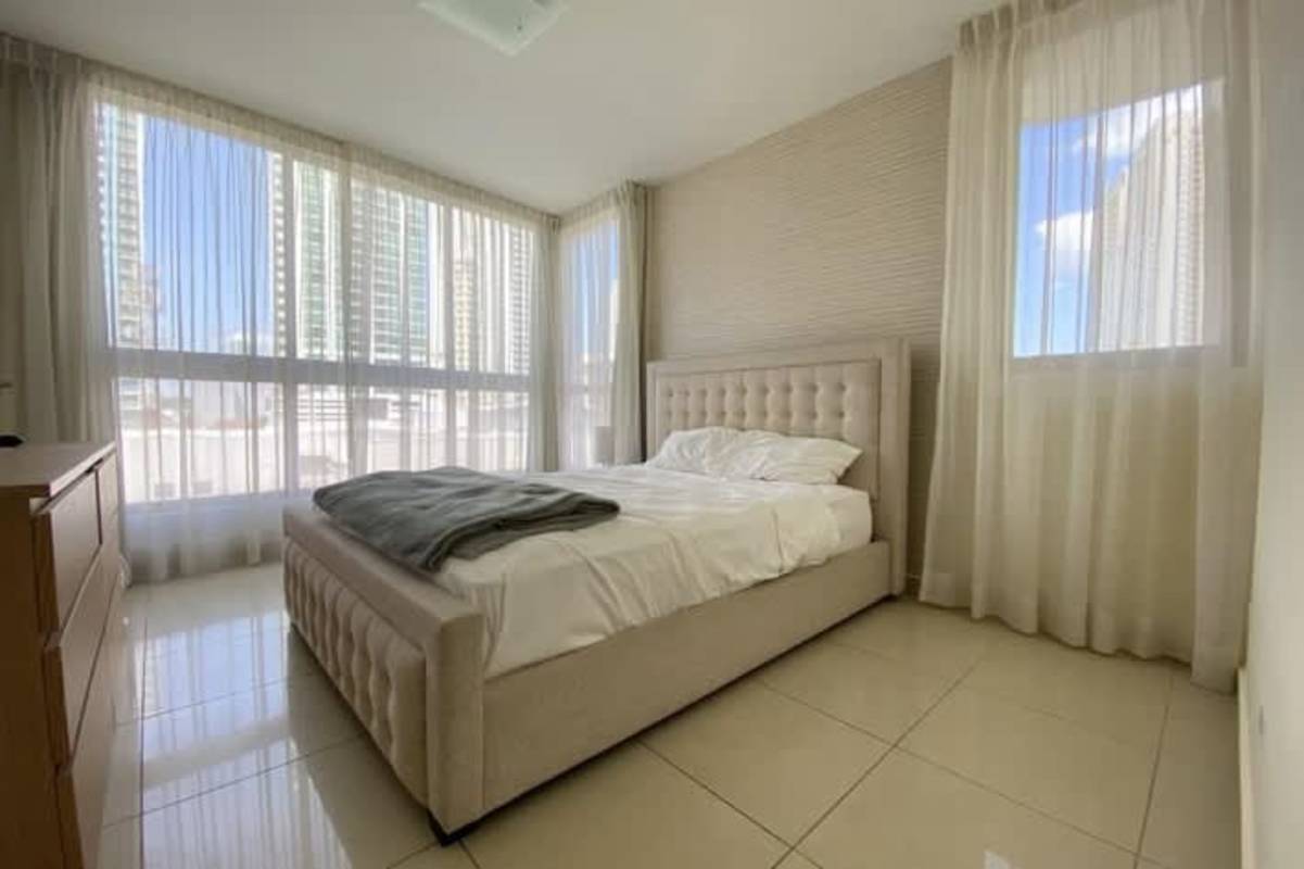 Modern bedroom with city view windows, upholstered bed in PH San Francisco Bay Panama