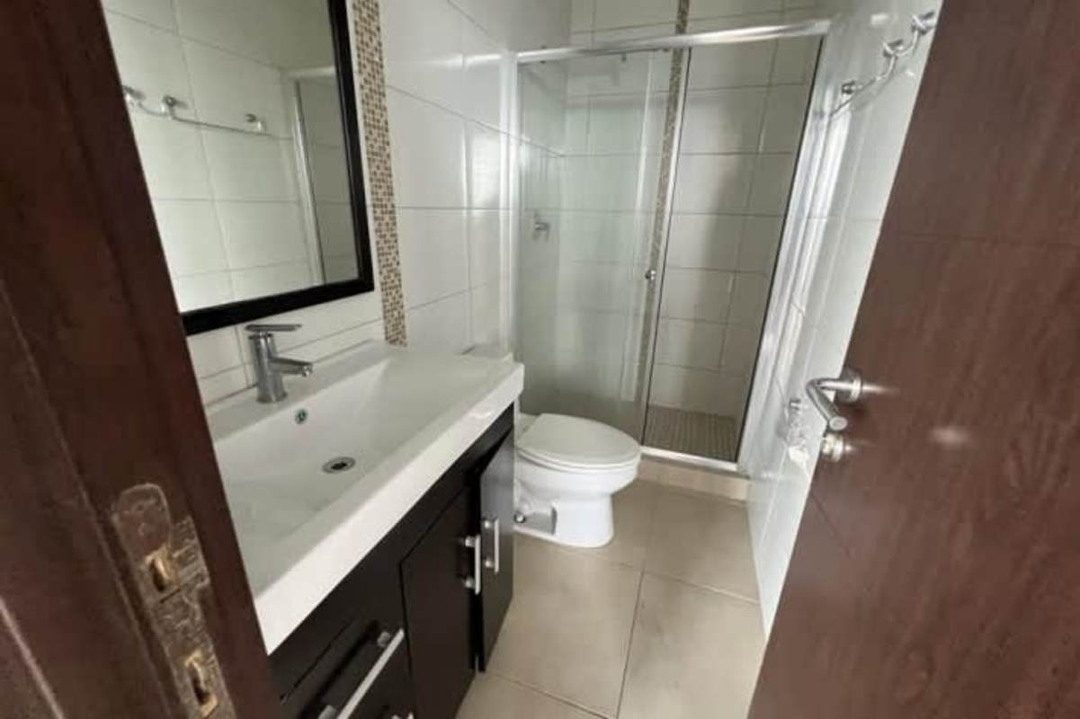 Living-dining room with sliding glass doors leading to balcony with city views PH Kings Park Condado del Rey