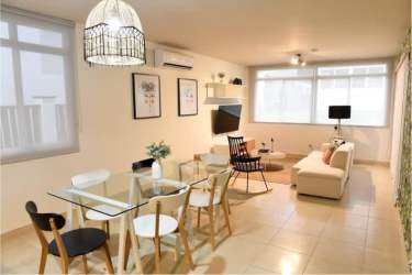 Lush tropical swimming pool with thatched umbrellas at Paradise Point Coronado