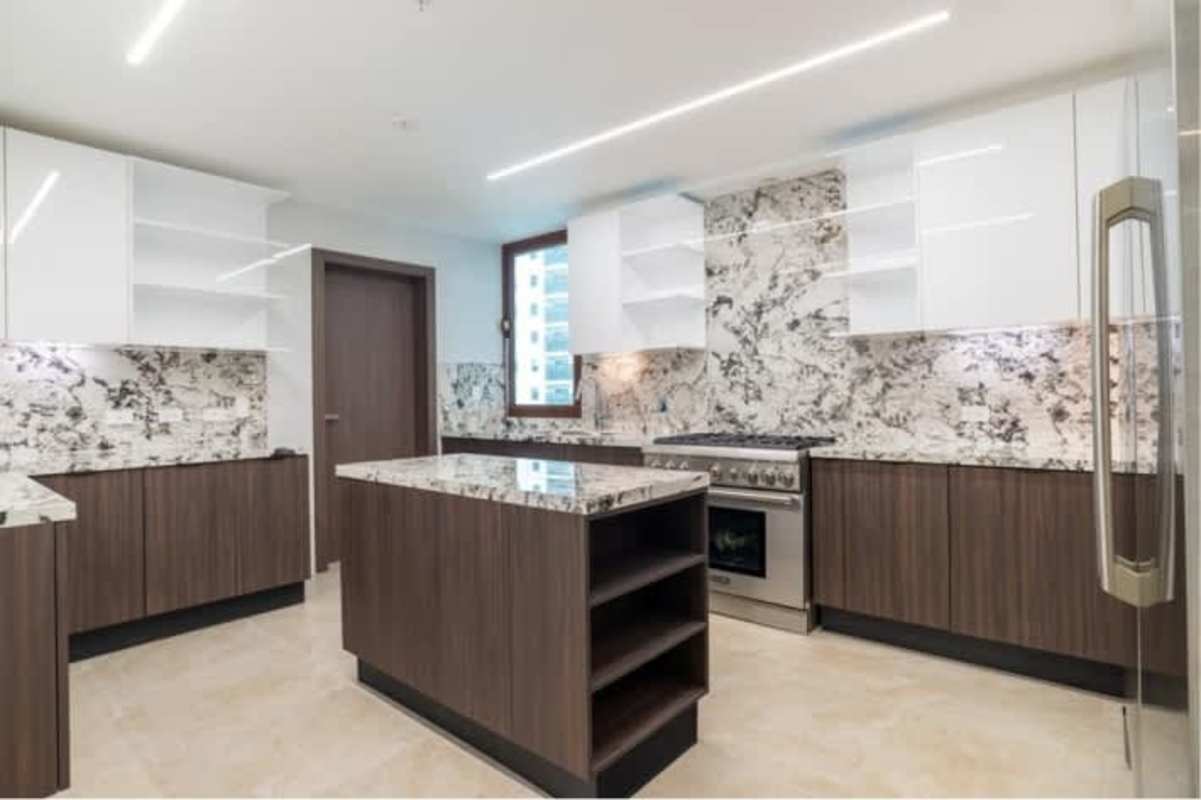 Spacious kitchen with granite countertop, island, and modern cabinetry at The Colonial Santa María Panama