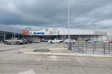 Modern shopping center with parking and storefronts next to vacant lot for sale Penonomé Panama