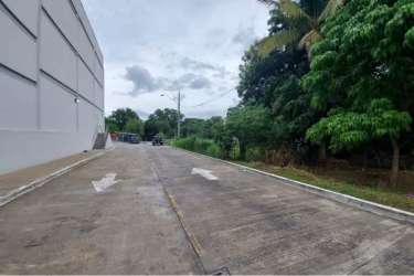 Paved driveway abutting large white building with trees at commercial land for sale Penonomé