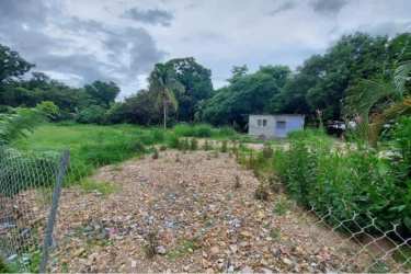 Vacant fenced lot with gravel and vegetation in Penonomé commercial area near Plaza Xtra