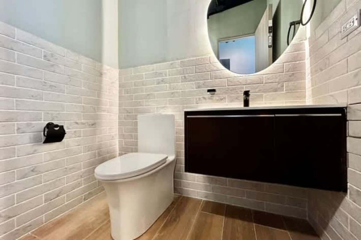 Modern bathroom with floating vanity, mirror, brick-pattern tiles Tower Financial Center Obarrio Panama