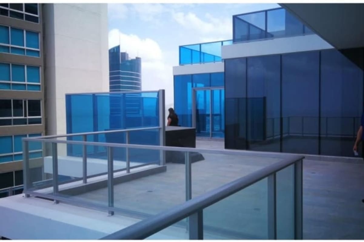 Expansive terrace with glass railing overlooking Pacific Ocean and city skyline Costa del Este Panama