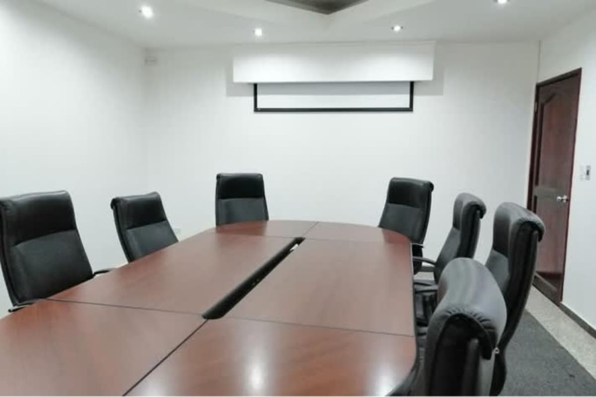 Modern conference room with wooden table, leather chairs, and recessed lighting in premium office Panama