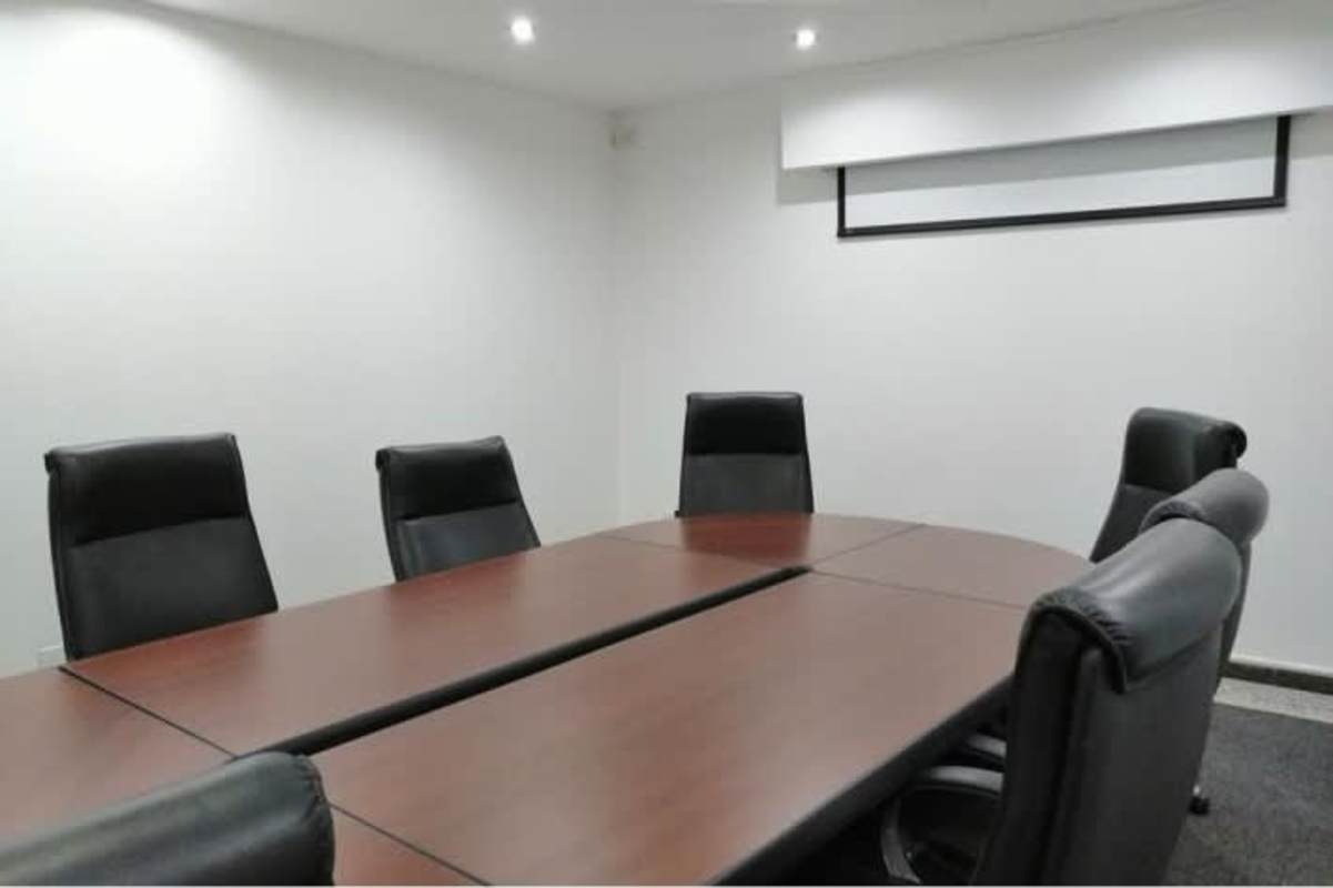 Corporate conference room with wooden table, leather chairs, projection screen Obarrio Panama