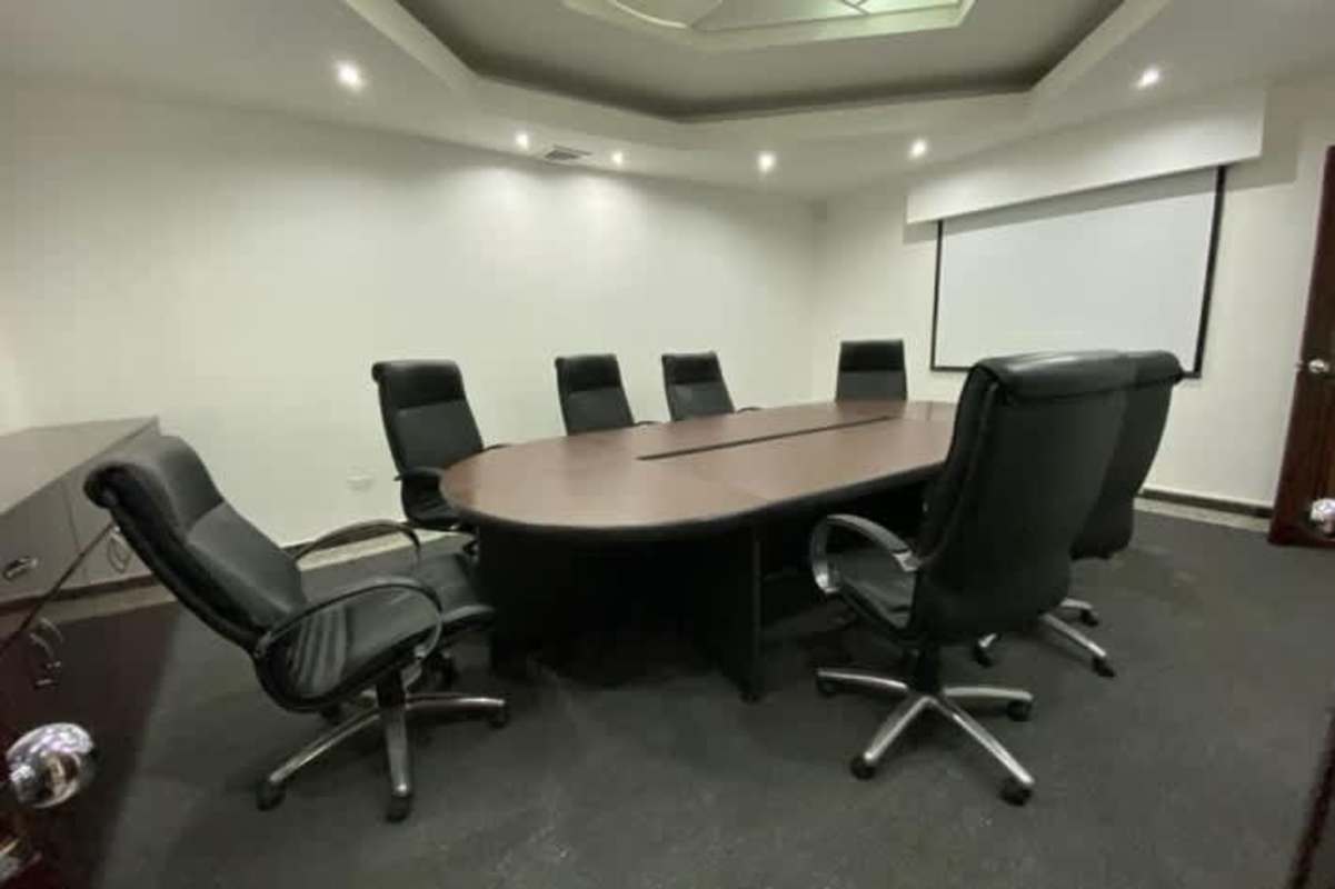 Conference room with large wooden table, executive chairs at PH BICSA Tower commercial office in Panama