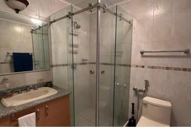 Modern bathroom with granite countertop and glass shower enclosure beachfront condo Farallón