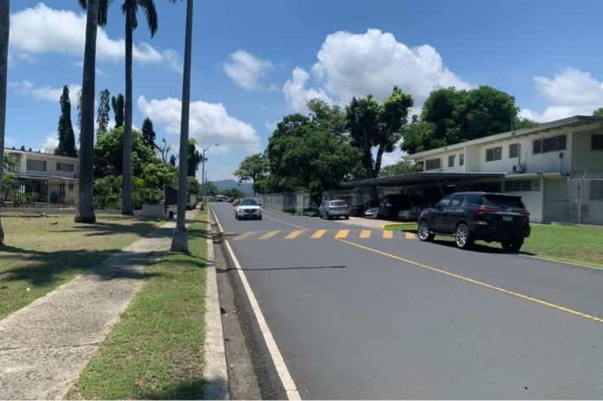 Street view of commercial lot with mature trees along main road La Boca near Albrook Panama City