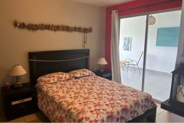 Bedroom with balcony sliding doors, floral bedspread in beach villa Ibiza Residences Panama