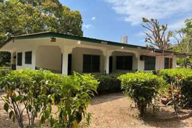 Basic shared bedroom, three beds, barred windows, tiles and AC unit