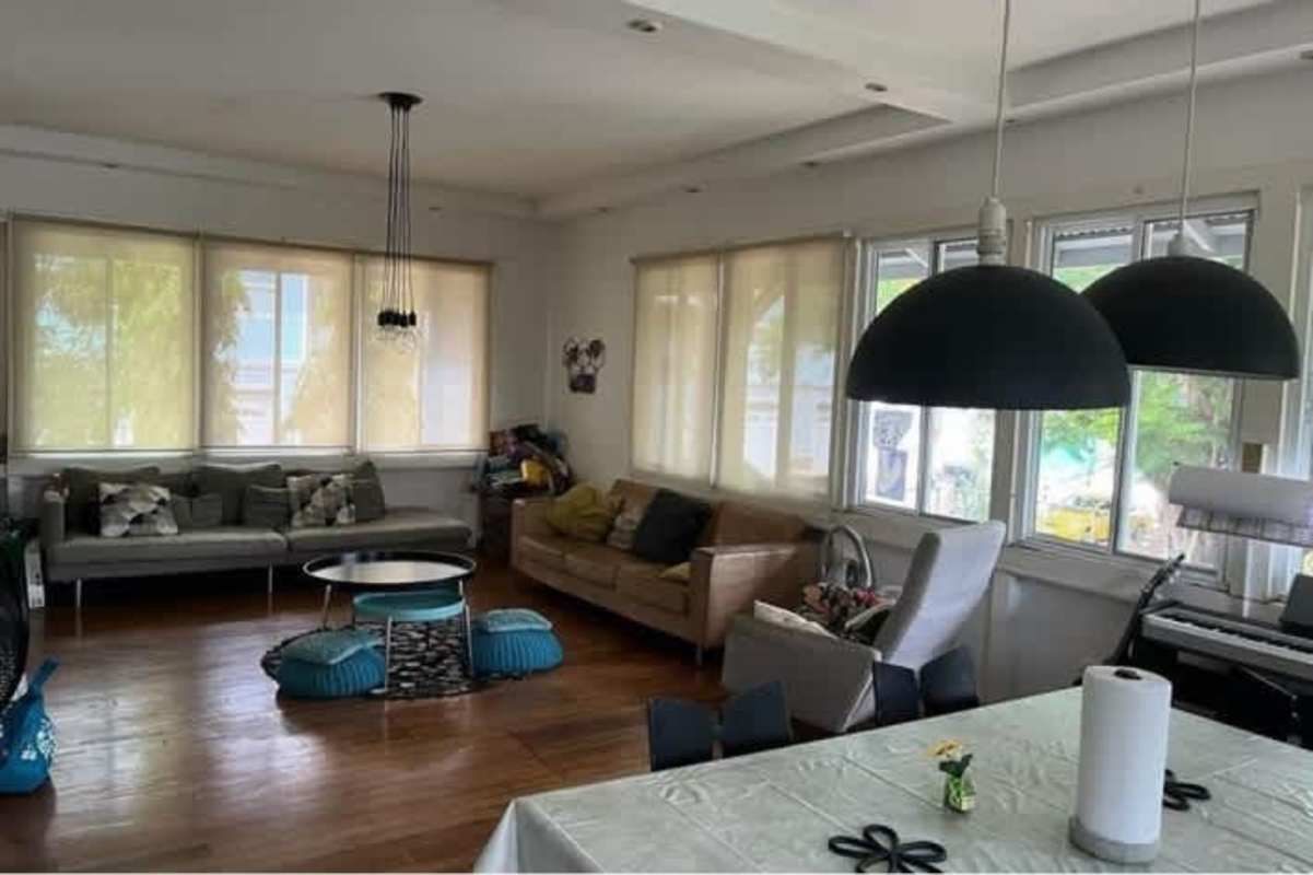 Large living and dining area with wood floors, big windows in Balboa Panama home