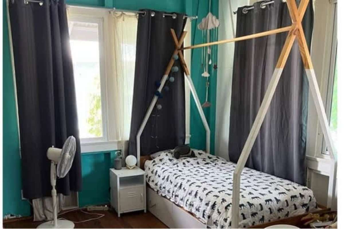 Fun kids bedroom with teepee bed and teal walls in Balboa Ancón house Panama