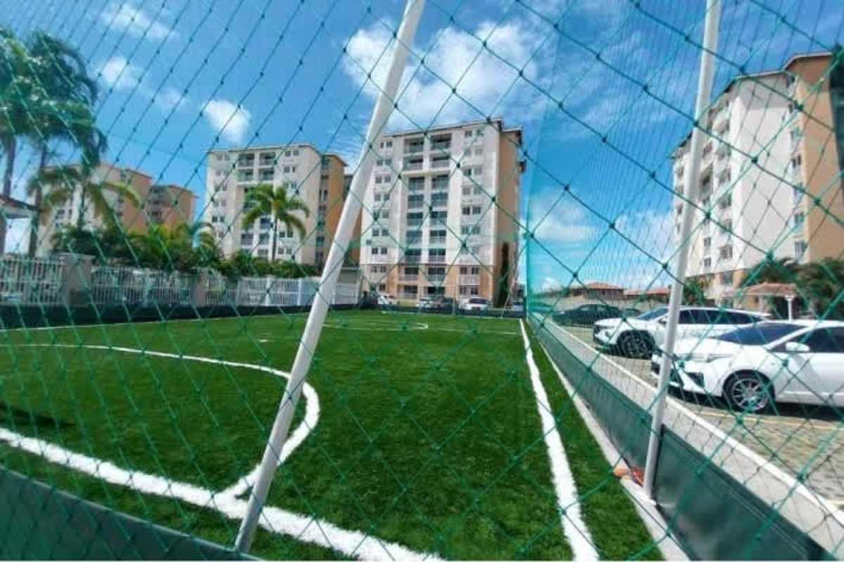 Outdoor soccer field with safety netting, playground, landscaped areas inside Residencial Versalles Panama City