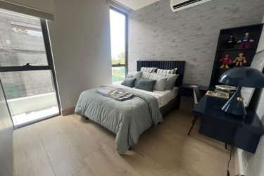 Modern bedroom with accent wall, blue bedding, large window Explora Panama Pacifico Panama