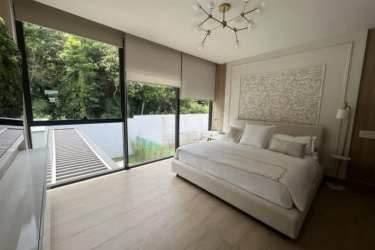 Spacious master bedroom with large windows, ensuite bath and garden views in Explora Panama Pacifico