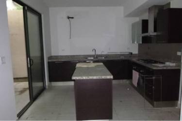 Modern kitchen with granite island, cabinets, sliding glass door to patio at PH Nativa