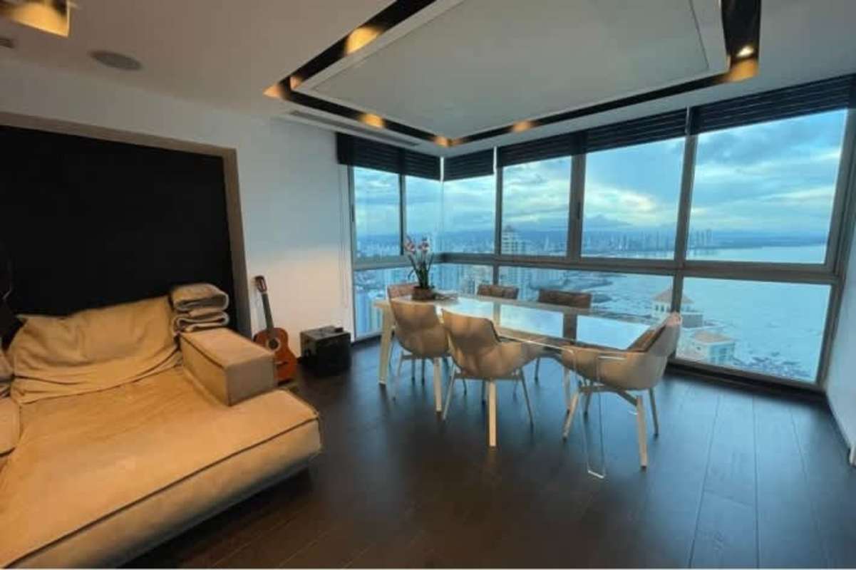 Open plan luxurious dining and living area with floor-to-ceiling windows and Pacific waterfront views in PH Aqualina