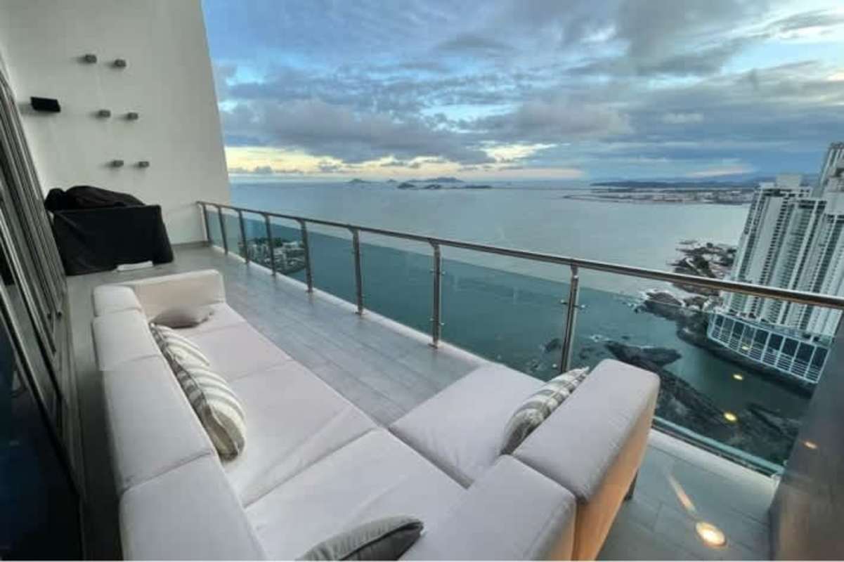 Modern high-rise balcony with glass railing and panoramic Pacific Ocean and Panama City skyline views in PH Aqualina