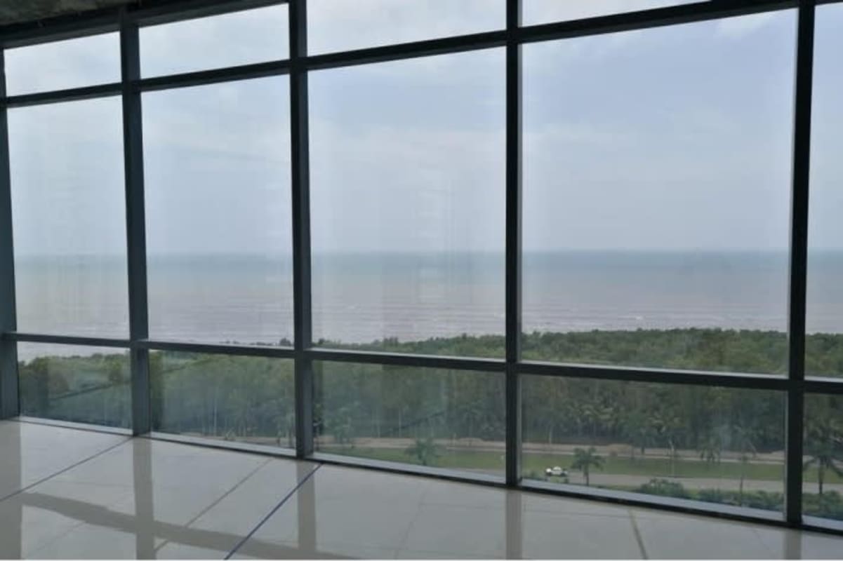 Empty high-rise interior space with floor-to-ceiling glass windows panoramic ocean and skyline Costa del Este Panama