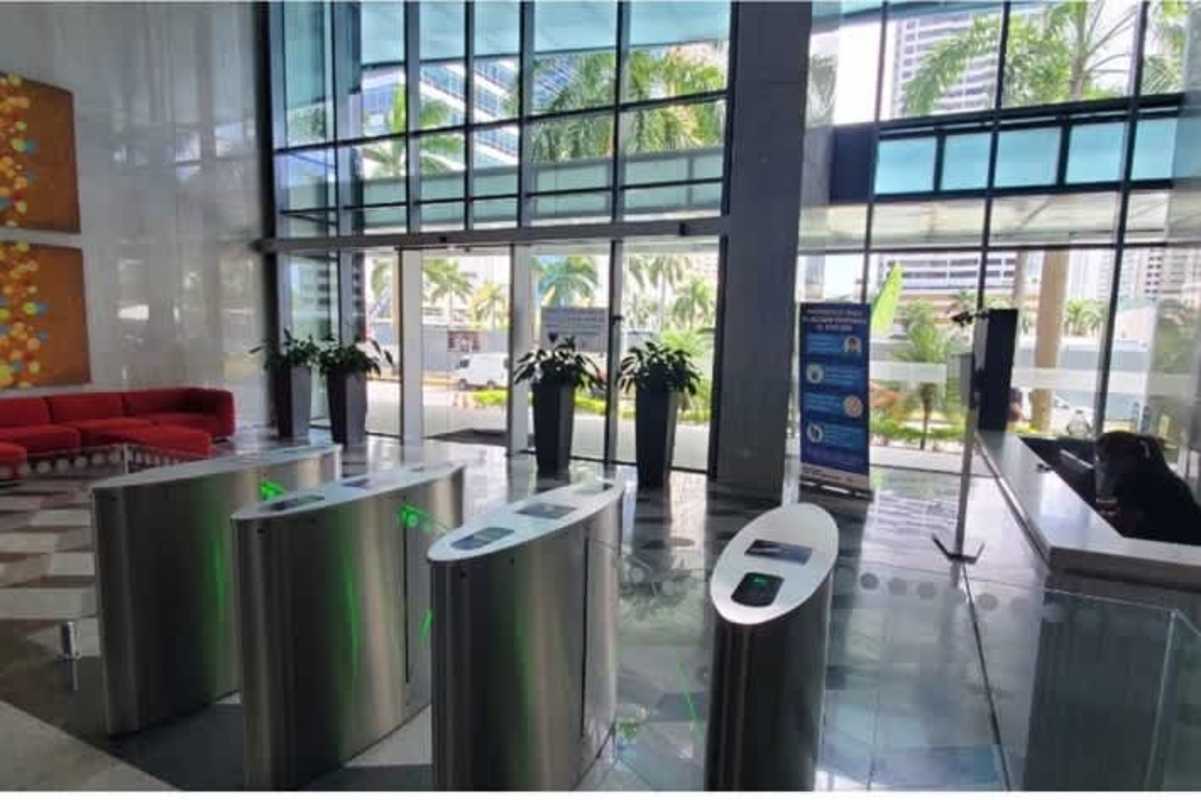 Modern reception lobby with security turnstiles, red sofas, glass walls Prime Time Tower Costa del Este