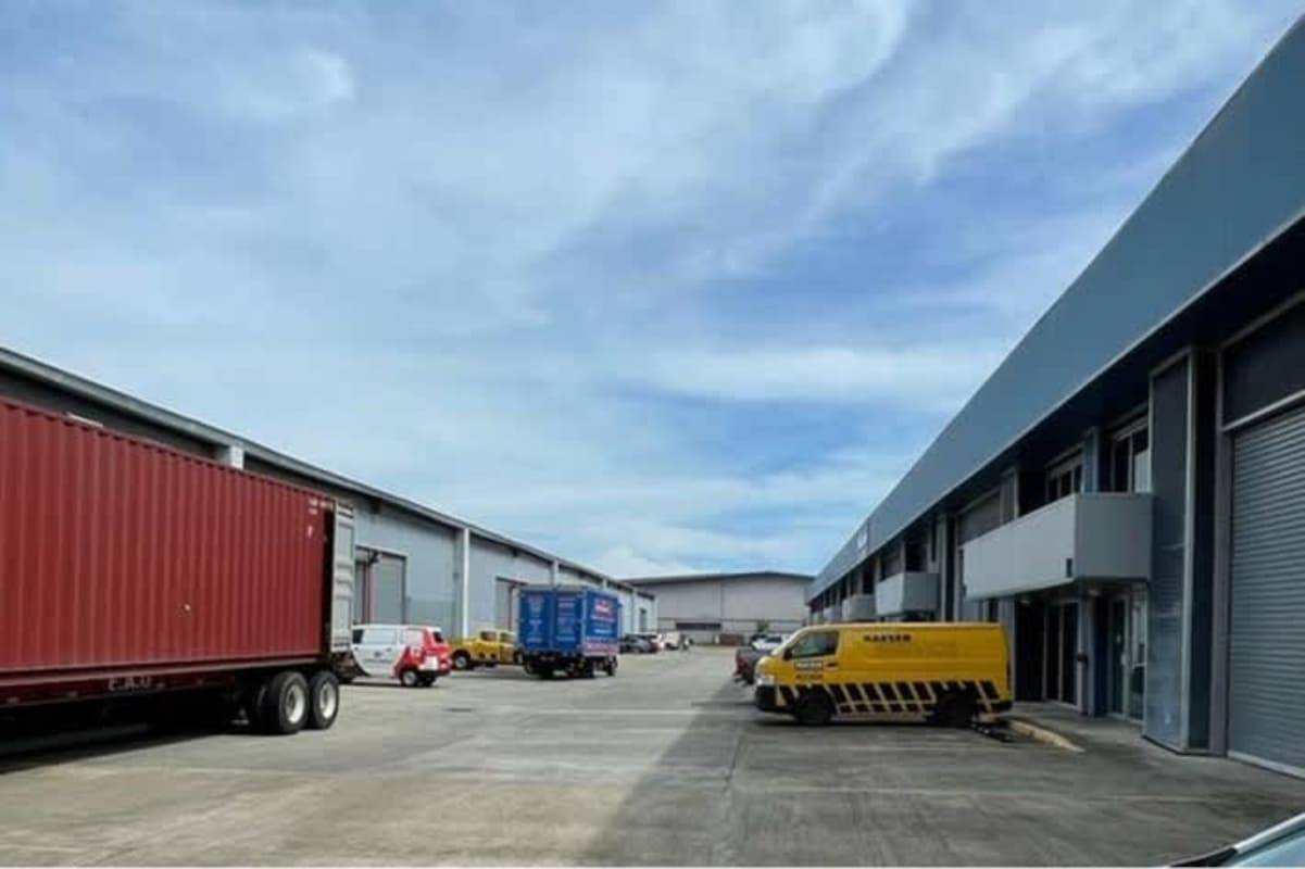 View of empty high clearance warehouse with metal beams mezzanine office and roll-up door Tocumen Panama