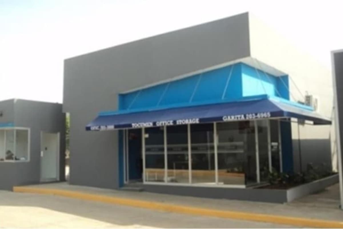 Facade view of Tocumen Office Storage with metro line above and signage in Panama
