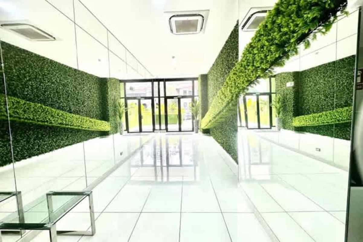 Designer lobby with green foliage wall, mirrored panels and bright reception in PH The Gray Panama City