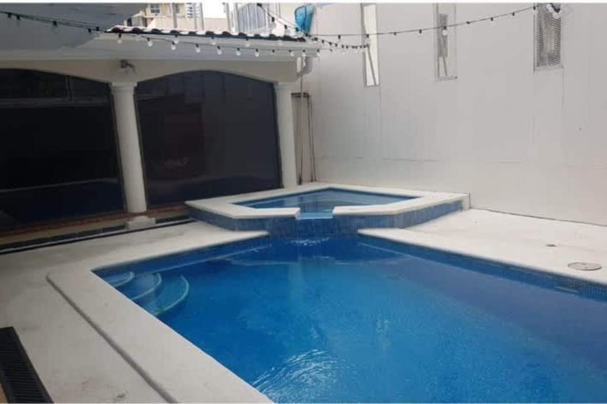 Covered carport area with columns tiled floor and garden La Alameda Betania