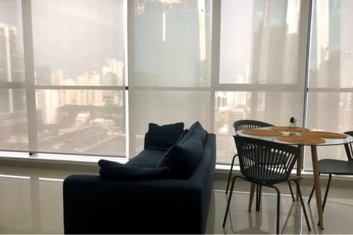 City skyline views from modern living room with large floor-to-ceiling windows in Obarrio Tower