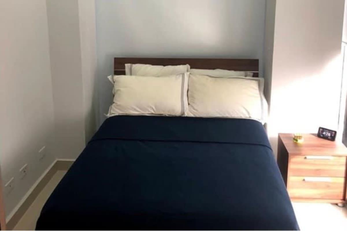 Bedroom minimalist blue bedding wood furniture Obarrio Tower rental Panama City