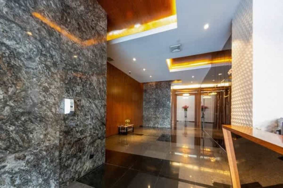 Elegant business plaza lobby with marble floors, wood details, lighting features at Plaza San Francisco Panama City