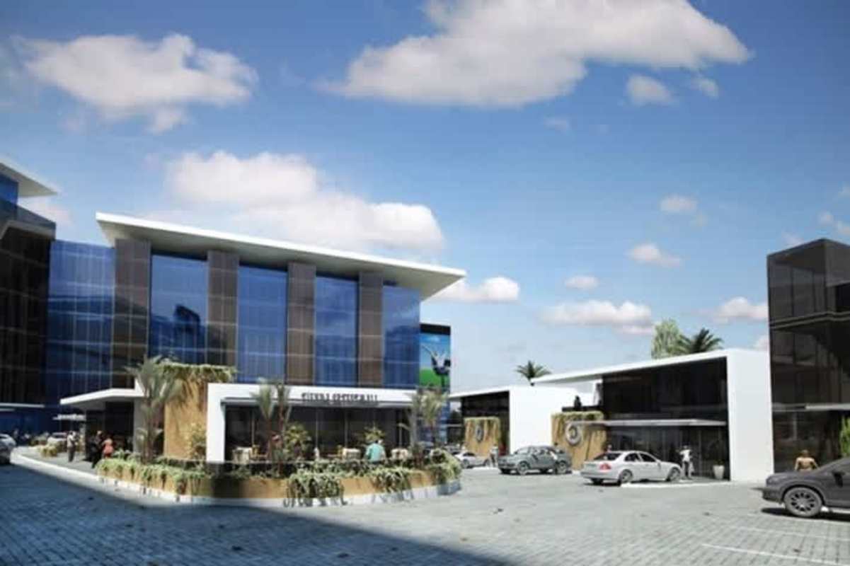 Contemporary commercial complex with glass facade, parking area, greenery in San Francisco Panama